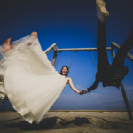glueckliches hochzeitspaar schaukelt am strand von st. peter-ording, froschperspektive, farbfoto - hochzeitsfotograf st. peter-ording