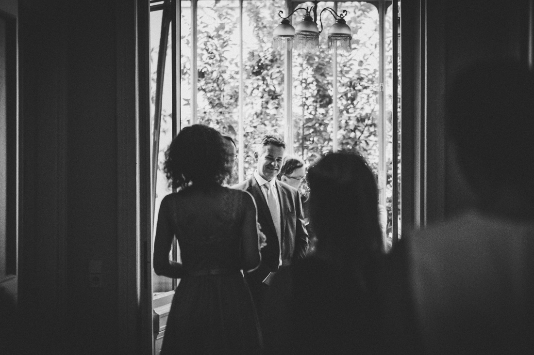 Hochzeitsfotograf Standesamt Gießen - Der Bräutigam empfängt die Gäste im kleinen Wintergarten der Villa Leutert