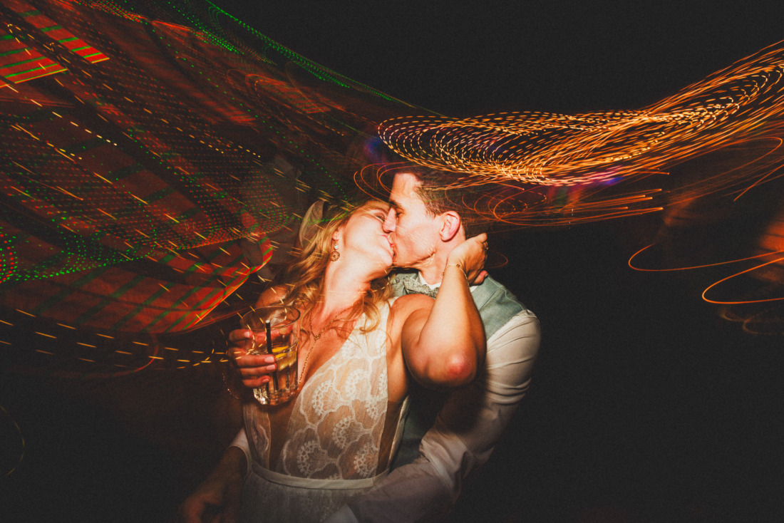 Hochzeitspaar küsst sich auf der Hochzeitsparty mit Lichtspuren und kreativem Blitz - fotografiert von Rossi, Hochzeitsfotograf Gießen