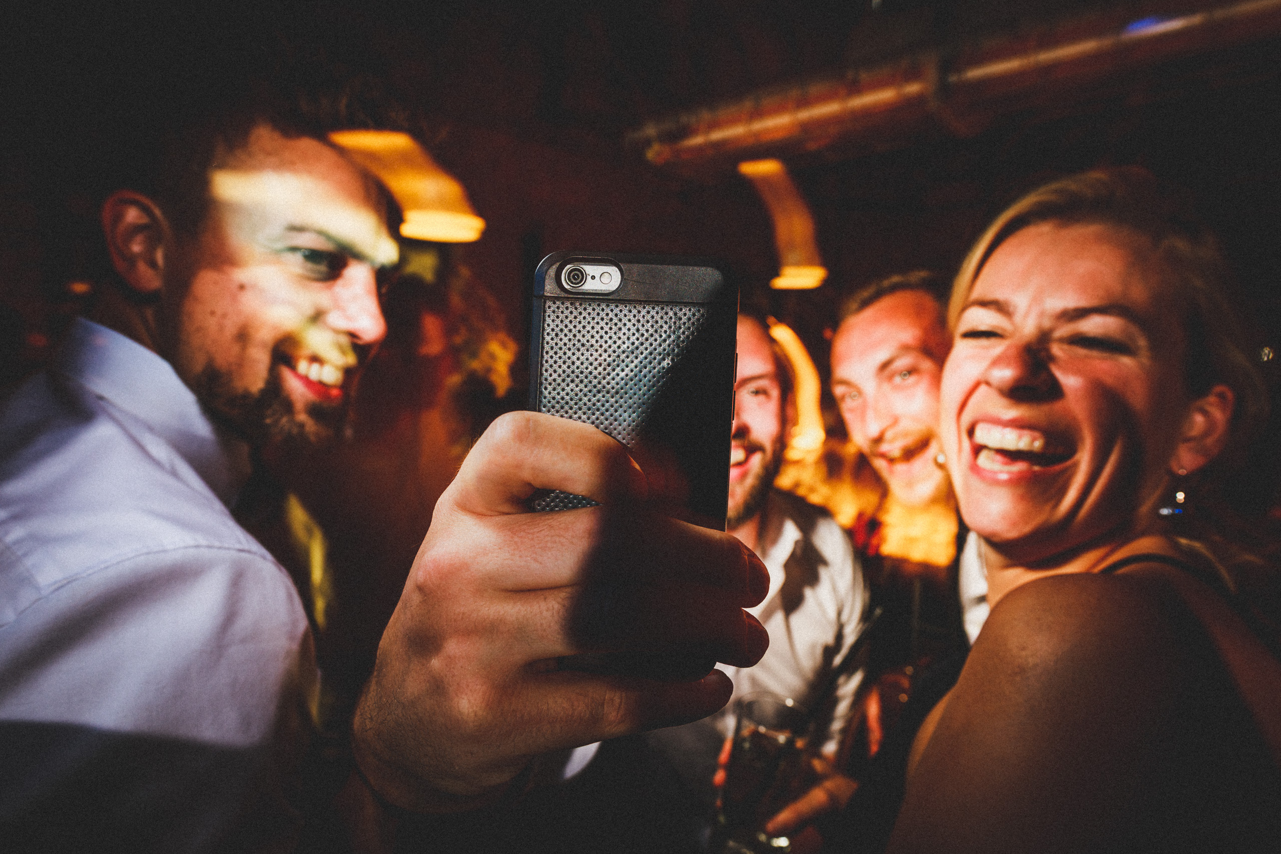 Gäste machen ein Selfie auf der Hochzeitsparty und lachen ausgelassen - fotografiert von Rossi